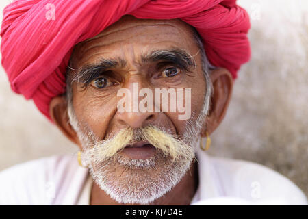 Portrait d'un manwith Rabari moustaches habillé en vêtements blancs traditionnels et du turban dans la campagne près de Jodhpur, Rajasthan, Inde. Banque D'Images