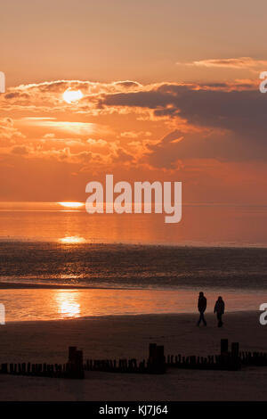 Deux personnes marchant sur la plage au coucher du soleil, la laver, Hunstanton, Norfolk, UK Banque D'Images