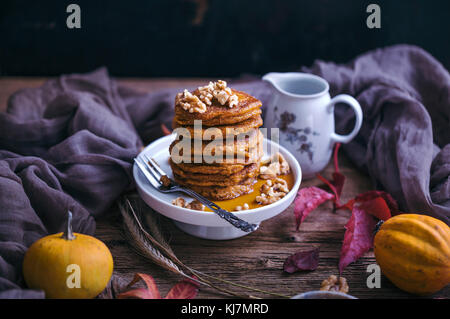 Crêpes à la citrouille Garnie de noix et sirop d'érable servi sur un petit gâteau position sur table en bois rustique Banque D'Images