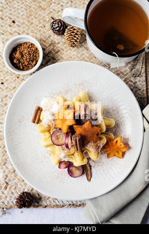 Table du petit déjeuner : gaufres avec fruits frais, cannelle et yaourt. Vue de dessus. Noël Banque D'Images