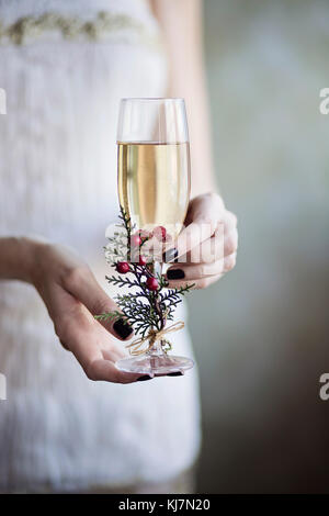 Célébration au champagne. Jeune femme tenant dans ses mains un verre de champagne Banque D'Images