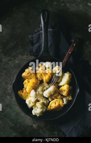 Carter en fonte de fer blanc et jaune soupe servi avec du vinaigre et vintage fourchette sur dark metal texture background. Mise à plat avec spa