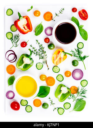 Composition des produits frais bio légumes (poivrons, oignons, concombres, carottes, tomates), les herbes, l'huile d'olive et vinaigres isolé sur fond blanc, top vi Banque D'Images