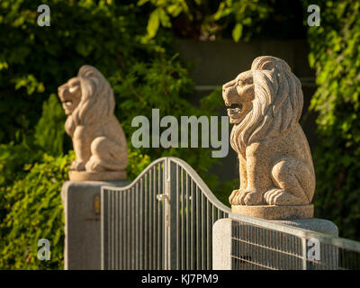 Deux lions en pierre sur des piliers qui garde l'entrée d'un jardin, Vienne Autriche Banque D'Images