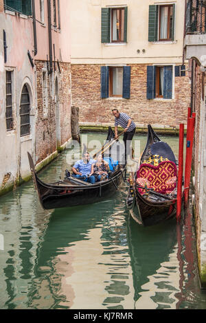 Une télécabine avec les touristes de passage un tombereau vide amarré dans un étroit canal, Venice Banque D'Images