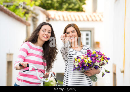 Deux belles amies, souriant et pointant vers quelque part Banque D'Images