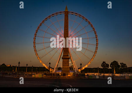 Paris, France. Une Grande Roue au crépuscule à la place de la Concorde, l'obélisque de Louxor et Le Jardin des Tuileries. Banque D'Images