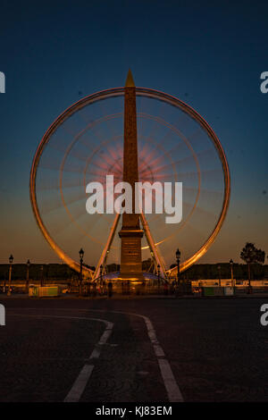 Paris, France. Une Grande Roue au crépuscule à la place de la Concorde, l'obélisque de Louxor et Le Jardin des Tuileries. Banque D'Images