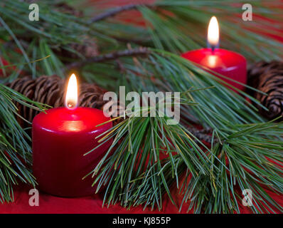 Bougies de Noël rouge avec des aiguilles de pin et les cônes Banque D'Images