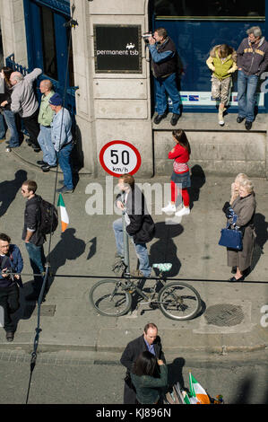 Homme debout sur un vélo à regarder le défilé des Forces militaires irlandais à l'Insurrection de Pâques 1916 Commémoration marche dans le centre-ville de Dublin Irlande Banque D'Images