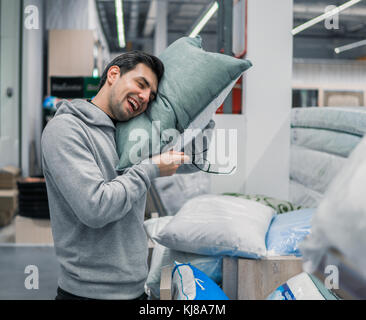 Le client choisit l'homme oreiller et linge de maison dans le supermarché Banque D'Images