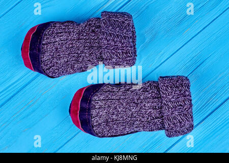Chaussettes de laine de couture sur fond bleu. Vue de dessus des chaussettes tricotées en laine chaude avec semelles textile sur fond de bois de près. prix chaussons de laine Banque D'Images