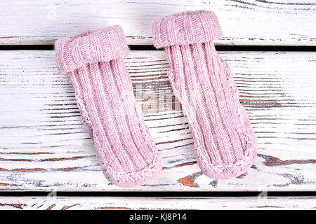 Paire de chaussettes tricotées en laine naturelle. rose pour filles chaussettes tricotées chaud blanc sur fond de bois fait main vêtement d'hiver pour enfants.. Banque D'Images