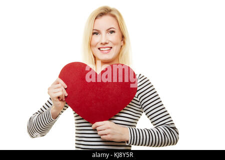 Jeune femme blonde possède un grand cœur rouge pour la Saint-Valentin ou la fête des mères Banque D'Images