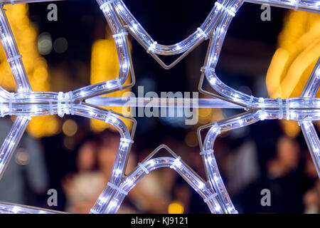 S de néons en forme de flocons de lumières sur la place dans la nuit. Décoration de Noël à l'extérieur. Banque D'Images