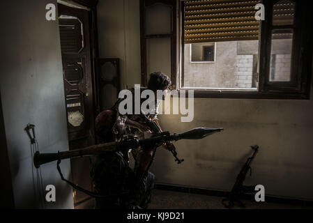 Raqqa, la Syrie. 12Th aug 2017. sdf vu les soldats qui gardaient la street à partir d'une fenêtre.en été 2017 les forces démocratiques syriennes (SDF) a lancé une bataille contre isis dans raqqa afin de reprendre le contrôle de la ville à partir de l'organisation terroriste. l'opération a donné lieu à au moins 3 000 morts y compris les combattants des deux côtés et civils. crédit : jake simkin/sopa/zuma/Alamy fil live news Banque D'Images