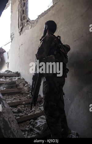 Raqqa, la Syrie. 12Th aug 2017. sdf fighter vérifie sur une position plus élevée possible pour les tireurs d'.en été 2017 les forces démocratiques syriennes (SDF) a lancé une bataille contre isis dans raqqa afin de reprendre le contrôle de la ville à partir de l'organisation terroriste. l'opération a donné lieu à au moins 3 000 morts y compris les combattants des deux côtés et civils. crédit : jake simkin/sopa/zuma/Alamy fil live news Banque D'Images