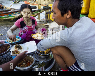 Yangon, région de Yangon, Myanmar. 23 novembre 2017. Un distributeur de nourriture sert les clients au marché aux poissons de San Pya. Le marché aux poissons de San Pya est l'un des plus grands marchés aux poissons de Yangon. C'est un marché ouvert 24 heures sur 24, mais le plus fréquenté tôt le matin. La plupart des poissons sur le marché sont capturés à l'état sauvage, mais l'aquaculture est en expansion au Myanmar et plus de poissons d'eau douce d'élevage sont vendus maintenant que par le passé. Crédit : Jack Kurtz/ZUMA Wire/Alamy Live News Banque D'Images