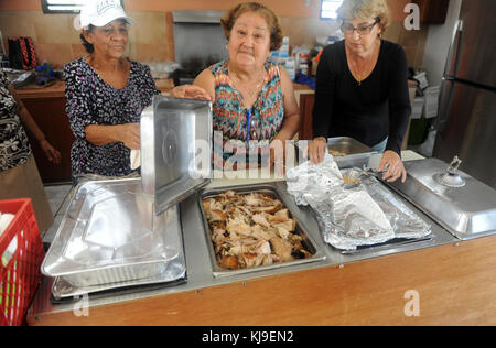 Bénévoles Ana Luis Vazquez, à gauche, Dalila Gonzalez, et Mary Rolon, à droite, présentez un plateau de dinde rôtie pour Thanksgiving au Centro de Bendicion le 22 novembre 2017 à San Juan, Porto Rico. Des bénévoles ont servi des repas de Thanksgiving dans le quartier de San Juan durement touché par l'ouragan Maria. Banque D'Images