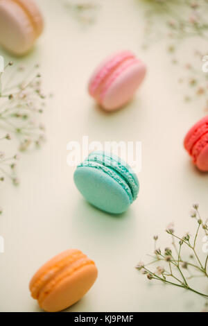 Matin cake macaron et fleur gypsophila sur fond vert clair à partir de ci-dessus. petit-déjeuner confortable. télévision style laïcs. Banque D'Images