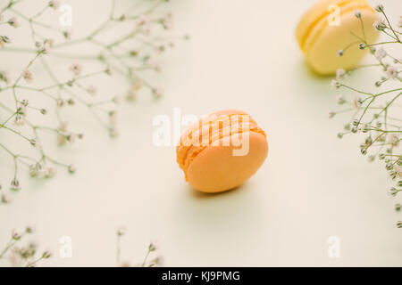 Matin cake macaron et fleur gypsophila sur fond vert clair à partir de ci-dessus. petit-déjeuner confortable. télévision style laïcs. Banque D'Images