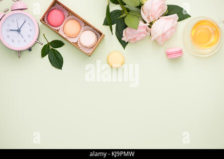 Macarons colorés et des fleurs rose avec boîte-cadeau sur table en bois. sweet macarons en boite cadeau. Vue de dessus Banque D'Images