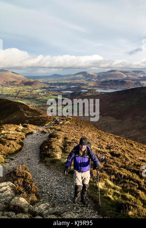 Walker sur la giboulée Comment Chemin sur Grisedale Pike à Keswick et Derwent Water derrière, Lake District, Cumbria, Royaume-Uni Banque D'Images