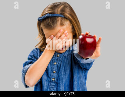 Studio portrait of cute girl holding a fresh red apple Banque D'Images