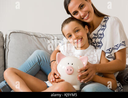 Mère et fille avec une tirelire pour son avenir des économies Banque D'Images