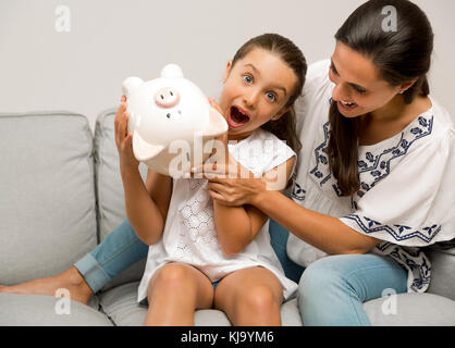 Mère et fille avec une tirelire pour son avenir des économies Banque D'Images