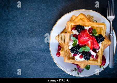 Gaufres maison doux avec de la crème glacée et sauce aux petits fruits de la plaque,focus sélectif et l'espace vierge Banque D'Images