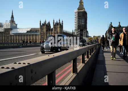 Close-up de la sécurité publique anti crash barrières libérées provisoirement sur le pont de Westminster à Londres en passant par taxi avec des chambres du Parlement dans l'arrière-plan. Banque D'Images