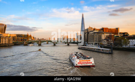 Vue depuis la passerelle du millénaire vers le fragment et le Tower Bridge avec un bateau de croisière de la ville passant sur la Tamise. Avec Tilt Shift effet. Banque D'Images