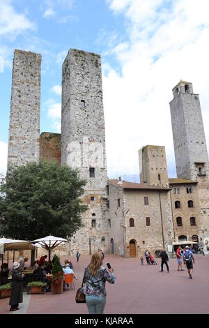 Touristes dans le centre de San Gimignano, Toscane, en regardant les tours emblématiques. Banque D'Images