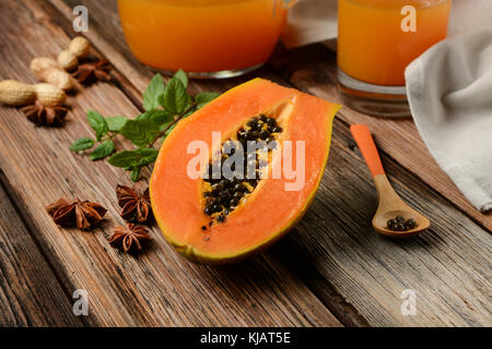 La papaye avec les feuilles de menthe sur table en bois - libre Banque D'Images