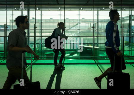 Les passagers à pied dans l'aérogare à l'aéroport Paris Charles de Gaulle, l'aéroport de Roissy, aka en france. Banque D'Images