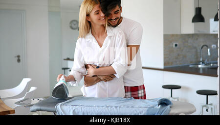 Un couple amoureux ironing clothes Banque D'Images