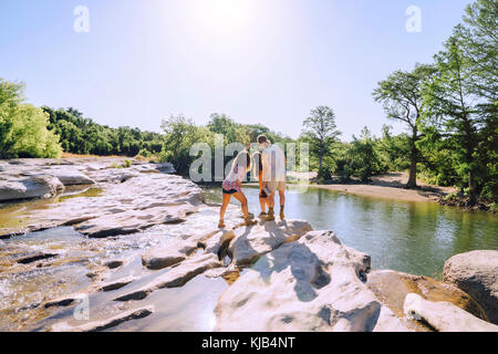 Friends posing for cell phone sur des rochers près de river selfies Banque D'Images