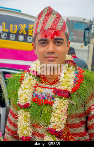 Pokhara, Népal, 10 octobre 2017 : portrait d'un bel homme portant des fleurs autour du cou et portant des vêtements typiques et des villageois en train de célébrer un mariage népalais à besisahar, Népal Banque D'Images