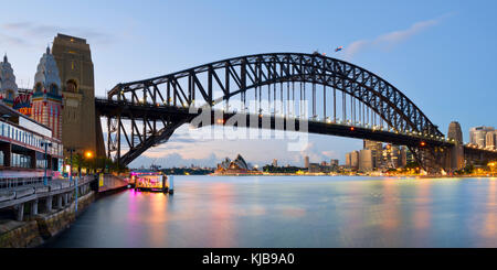 Photographie panoramique de l'Harbour Bridge et l'Opéra de Sydney de Luna Park à Milsons Point, Sydney, NSW, Australie juste avant le lever du soleil. Banque D'Images