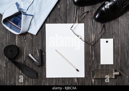 Homme d'ensemble d'accessoires de mode et le papier blanc au milieu, vue du dessus sur fond de bois blanc Banque D'Images