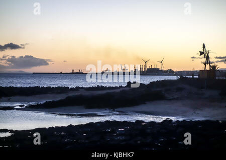 LANZAROTE, ESPAGNE-4 nov 2017: Coucher de soleil dans la principale station touristique de Costa Teguise avec la principale centrale électrique de l'île pour l'approvisionnement énergétique à l'arrière Banque D'Images