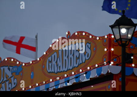 Concept d'essayer de profiter des négociations sur le Brexit, montré par des drapeaux sur la jetée de Paignton un jour venteux avec le signe des Grabbers, Paignton, Devon, Royaume-Uni Banque D'Images