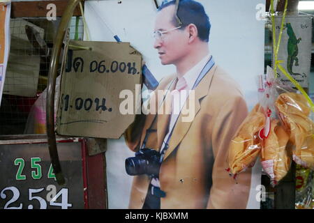 Une affiche de la fin Thai le roi Bhumibol Adulyadej, connu sous le nom de Rama IX, avec un appareil photo autour du cou, dans un marché le long de la rivière à Bangkok, Thaïlande. Banque D'Images