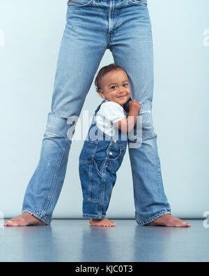 Bébé tenant sur les jambes de mère Banque D'Images