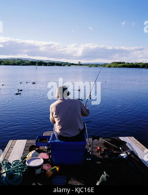 Homme pêche au large de Dock, port à Drumshanbo, Lough Allen, Leitrim, Irlande Banque D'Images