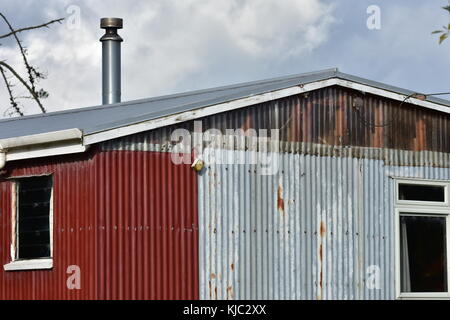 Shed fabriqués à partir de carton ondulé partiellement en panneaux de tôle rouillée. Banque D'Images