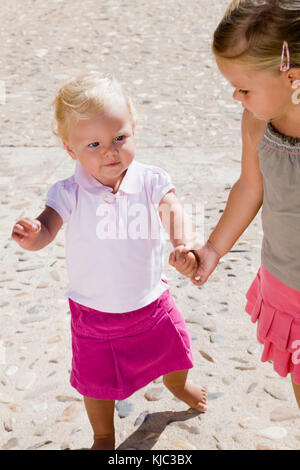 Enfant aidant soeur à marcher Banque D'Images