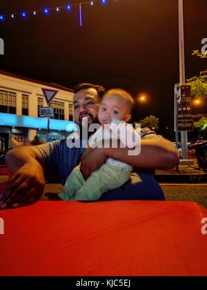 Johor Bahru, Malaisie - 15 octobre 2017 : un père et son bébé, les clients à Bandar Baru Uda camions alimentaire bazar, Johor, Malaisie. Banque D'Images