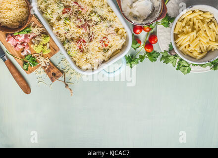 Casserole de pâtes avec du chou romanesco et au jambon en sauce crémeuse prête à cuire, sur une table de cuisine avec des ingrédients d'arrière-plan, Vue de dessus, frontière. italia Banque D'Images